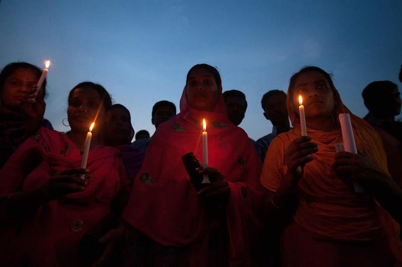 Bangladeshi garment workers and relatives of victims of the Rana Plaza building collapse hold candles during a memorial. Suvra Kanti Das / AFP Photo