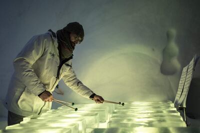 A musicians performs with an ice xylopone during a concert in the "Ice Dome" on Presena Galcier, Tonale Pass, near Trento in northern Italy on January 17, 2018. When Tim Linhart started making instruments from ice they were more likely to explode with a bang than produce music, but things have come a long way since then. Today, the US-born artist is in charge of an ice orchestra playing a series of concerts at sub-zero temperatures in a vast, custom-built igloo high in the Italian Alps. 
 / AFP / Marco BERTORELLO

