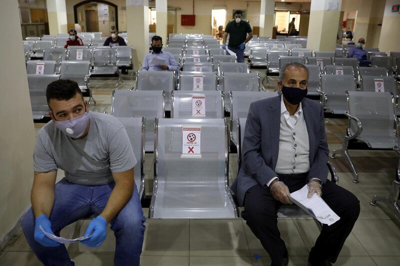 People  wearing protective face masks wait to complete their transactions in the Civil Status Department after Jordan's public sector employees returned gradually to work, two months after they were ordered to stay home as part of a tight lockdown to stem the spread of the coronavirus disease (COVID-19), in Amman, Jordan May 26, 2020. REUTERS/Muhammad Hamed