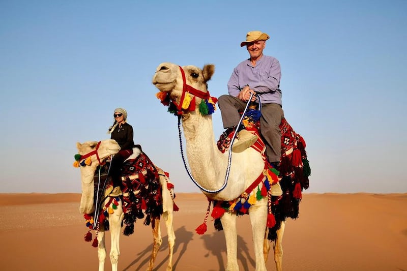 Mark Evans and Reem Philby ride camels on the Heart of Arabia expedition