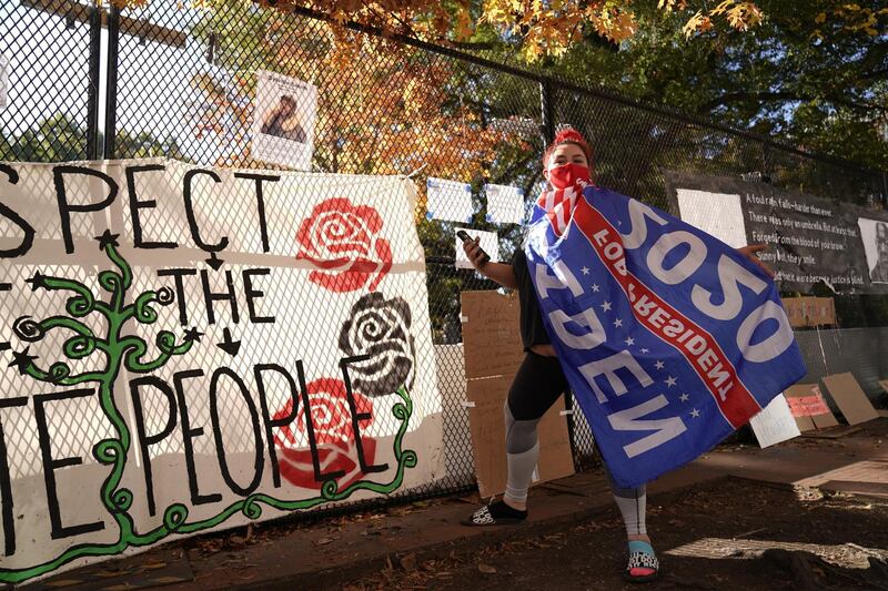 Jordan Johnson poses with a Biden flag outside the White House, in Washington.  Reuters