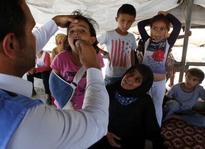 Palestinian children receive a medical check up from the United Nations Relief and Works Agency's (UNRWA) mobile team on the outskirts southern West Bank city of Hebron on August 9, 2018. - UNRWA provides support for more than three million Palestinians across the Middle East, including the majority of Gaza's two million residents. (Photo by HAZEM BADER / AFP)