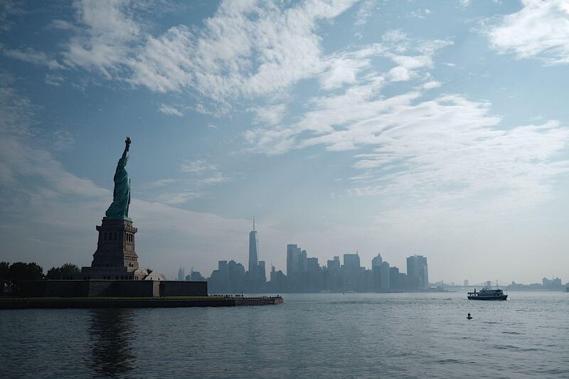 The reopened Liberty Island with the Statue of Liberty is pictured in front of the skyline of Lower Manhattan on July 20, 2020 in New York City. Just a few tourists visited the reopened monument as New York City moves into Phase 4 of the Coronavirus lockdown. / AFP / Johannes EISELE
