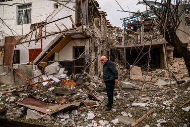 An elderly man stands in front of a destroyed house after shelling in the breakaway Nagorno-Karabakh region's main city of Stepanakert. AFP