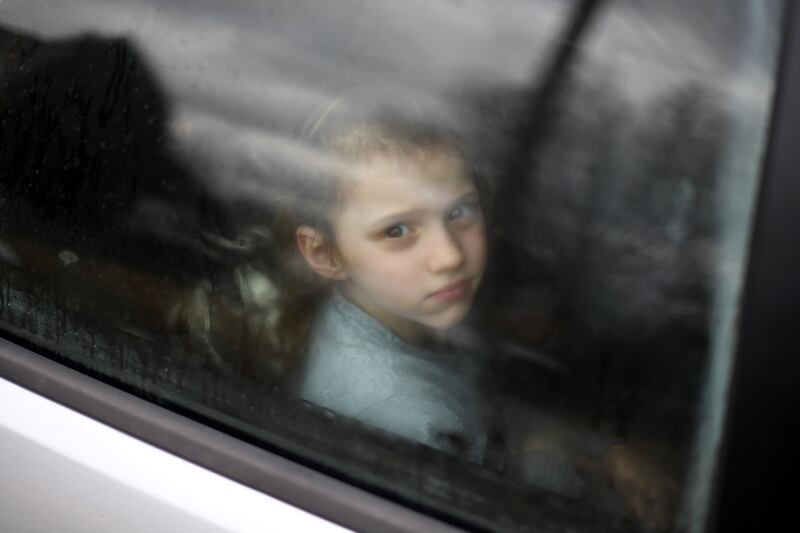 A Ukrainian child in a car stuck in traffic, as her family drives towards the Polish border to escape the conflict in their country. AFP