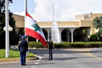 Presidential guards remove a Lebanese flag after the six-year term of former Lebanese president Michel Aoun officially ended, at Baabda Palace, east of Beirut, on November 1, 2022. EPA