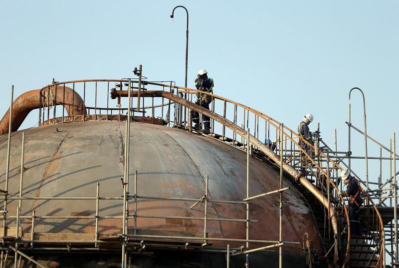 FILE PHOTO: Workers are seen at the damaged site of Saudi Aramco oil facility in Abqaiq, Saudi Arabia, September 20, 2019. REUTERS/Hamad l Mohammed/File Photo