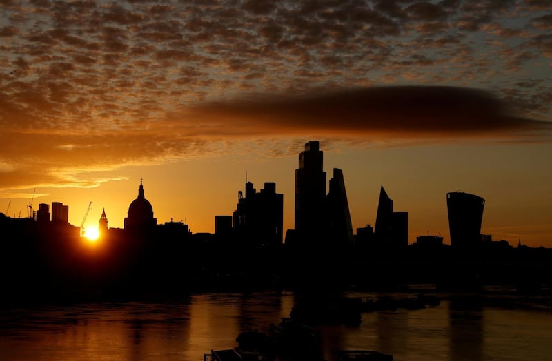 FILE PHOTO: The sun rises behind the skyline of St Paul's Cathedral and the City of London, in London, Britain, August 2, 2020. REUTERS/John Sibley/File Photo