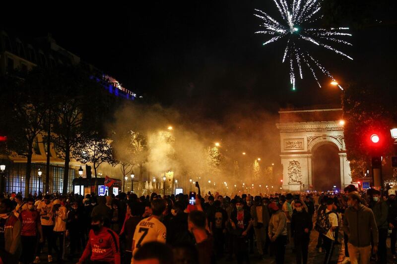 Paris Saint-Germain supporters walk on the Champs-Elysees and set off  fireworks in Paris. AFP