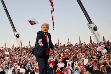 U.S. President Donald Trump throws a face mask from the stage during a campaign rally, his first since being treated for the coronavirus disease (COVID-19), at Orlando Sanford International Airport in Sanford, Florida, U.S., October 12, 2020. REUTERS/Jonathan Ernst