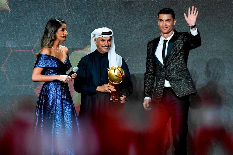 Juventus' Portuguese forward Cristiano Ronaldo (R) waves before receiving from Secretary General of Dubai Sports Council (DSC), Saeed Mohammed Hareb (C) the 433 Fans' Award during the 10th edition of the Dubai Globe Soccer Awards in Dubai. AFP