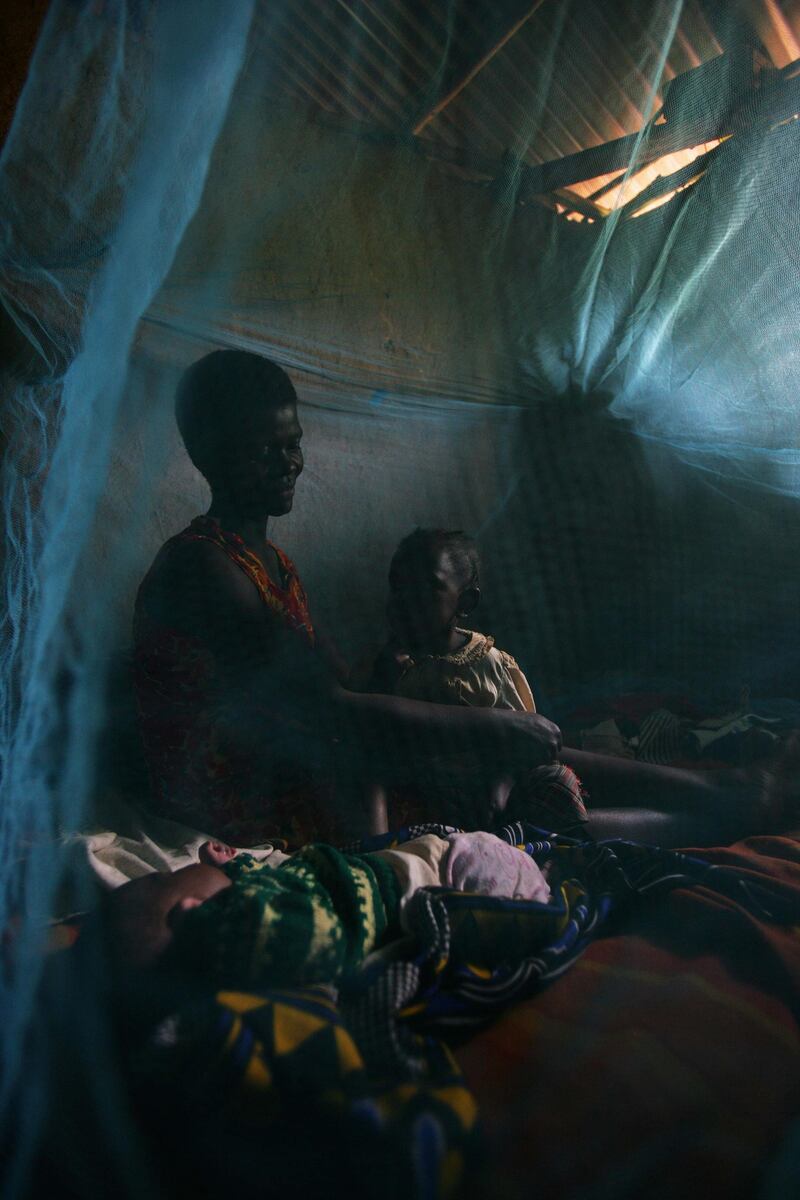 FOR MALARIA / SMALLPOX GALLERY. KISUMU, KENYA - SEPTEMBER 11: A rural woman and her children prepare for bed underneath donated repellent-impregnated mosqito netting in the Sauri Millenium village locale, September 11, 2007 in Kisumu, Kenya. Malaria rates in the area have dropped by over 400% as a result of the donated netting, freeing farmers of disease and making for a more productive populace. The Millenium Village concept is based on succesful production based on five years of initial structured financing of rural communities which allows small farmers to reach sustainability and the ability to support themselves.  (Photo by Brent Stirton/Getty Images)