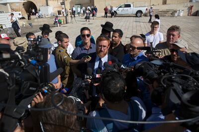 Israeli Knesset member Yehuda Glick, center, speaks to journalists after visiting at the Al Aqsa Mosque compound in Jerusalem's old city. Tuesday, Aug. 29, 2017.  Two Israeli lawmakers have visited a contested Jerusalem holy site for the first time in two years.Tuesday's visit, which passed peacefully, was meant to test the waters as Benjamin Netanyahu's government mulls whether to allow such visits to resume. They were banned in late 2015 for fear of sparking tensions.. (AP Photo/Sebastian Scheiner)