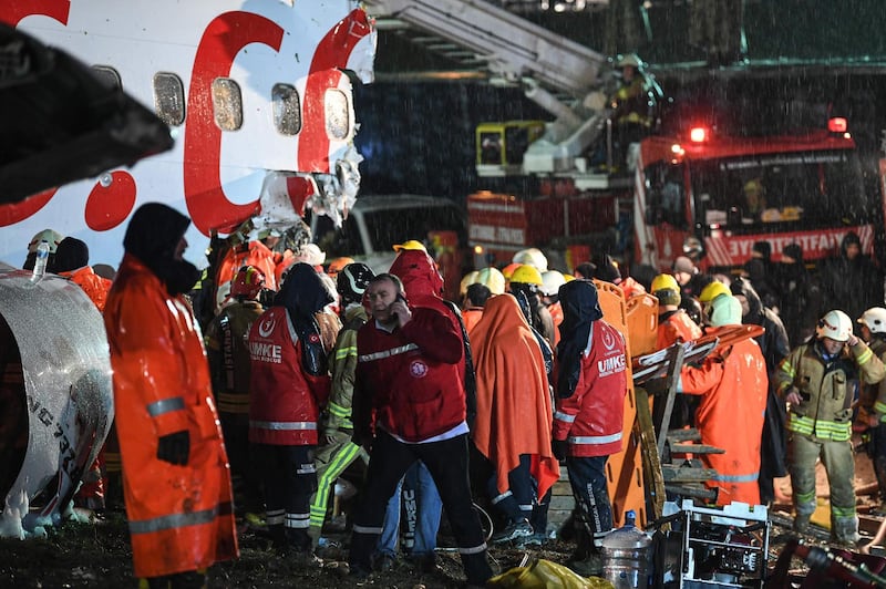 Rescuers work around the crash of a Pegasus Airlines Boeing 737 airplane, after it skidded off the runway upon landing at Sabiha Gokcen airport in Istanbul.  AFP