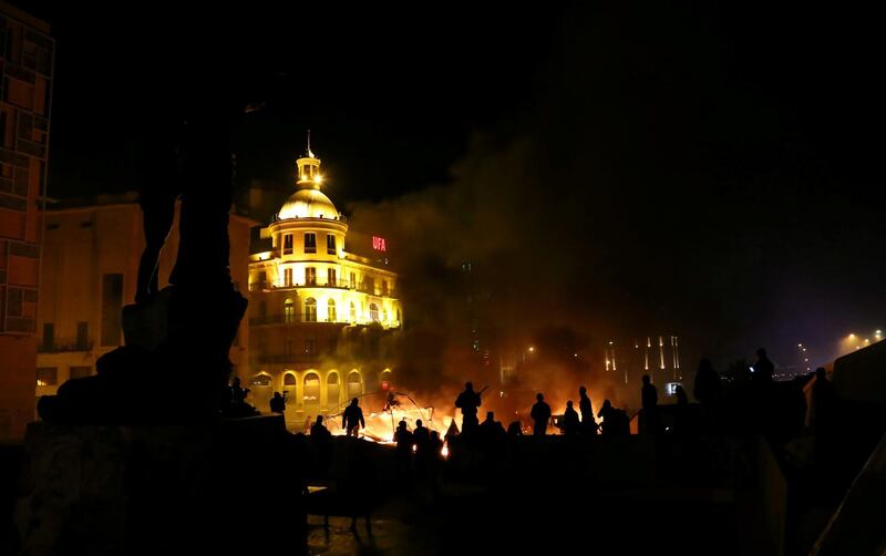 Protesters stand near burning tents during anti-government protests in Beirut. Reuters
