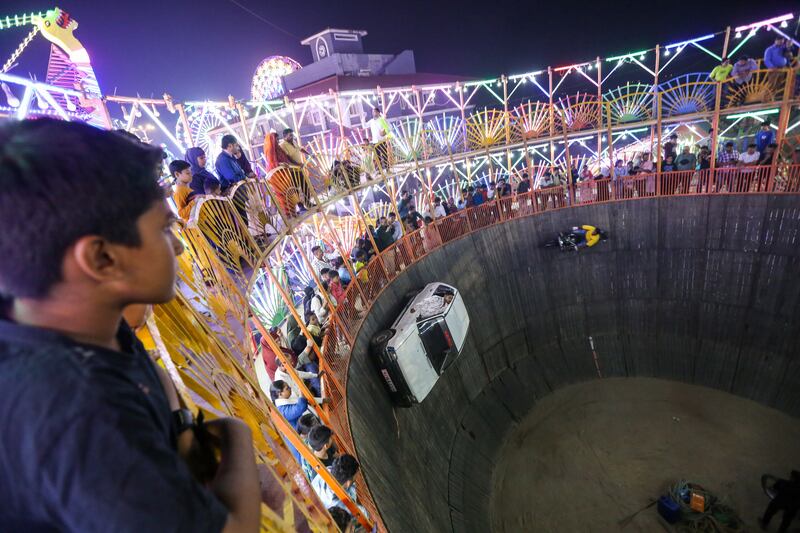 People watch performers at the 'Wall of Death' show in an amusement park during the annual Mahim Fair in Mumbai, India. EPA 