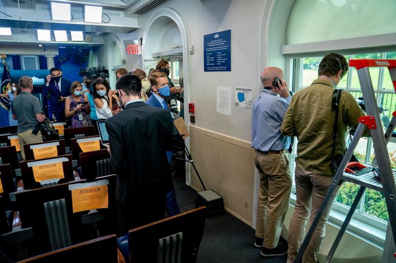 Members of the media look outside from the James Brady Press Briefing Room at the White House. AP Photo