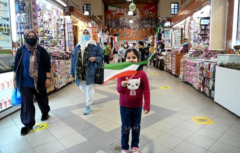 A girl waves the Kuwaiti flag at Kuwait City's Souk Al Mubarakiya. Events to mark National Day and Liberation Day on February 25 and 26 have been cancelled due to the coronavirus pandemic. EPA