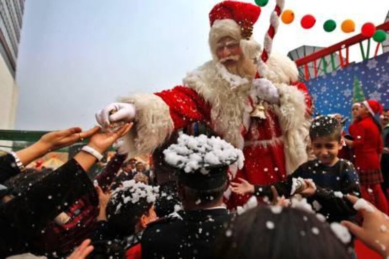 Santa Claus distributes sweets to children on the occasion of Christmas, at the hotel Le Meridien in New Delhi, India, Saturday, Dec. 25, 2010. Christians in India make up just over 2 percent of its 1 billion population. (AP Photo/Mustafa Quraishi) *** Local Caption ***  DEL122_India_Christmas.jpg