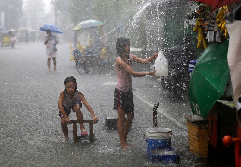 Girls play along a flooded street during heavy rains brought on by tropical storm 'Nesat' on the outskirts of Manila. Aaron Favila / AP Photo