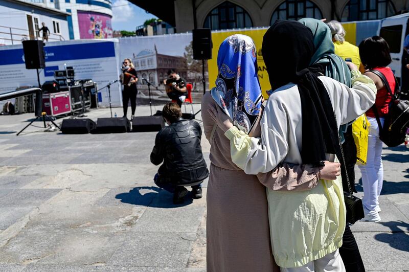 Women attend the performance of musician Ozge Metin, left, in Istanbul. AFP