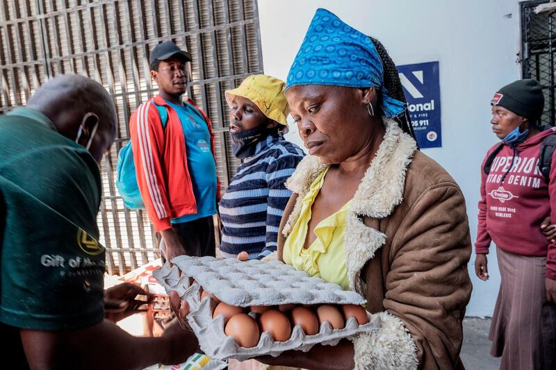 A blind woman collects her food parcel during a food distribution organised by Gift of the Givers in Johannesburg CBD, on October 14. Luca Sola / AFP