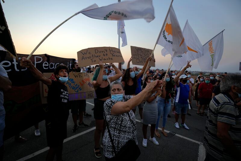 Residents of Famagusta hold Cypriot flags during a protest against a visit by Turkish President Recep Tayyip Erdogan, and the 47th anniversary of the Turkish invasion of the island, in Deryneia, Cyprus, on July 19. AP