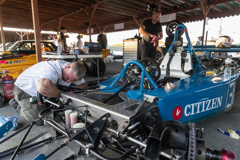 Race team members prepare the cars for two days of racing in the paddocks
