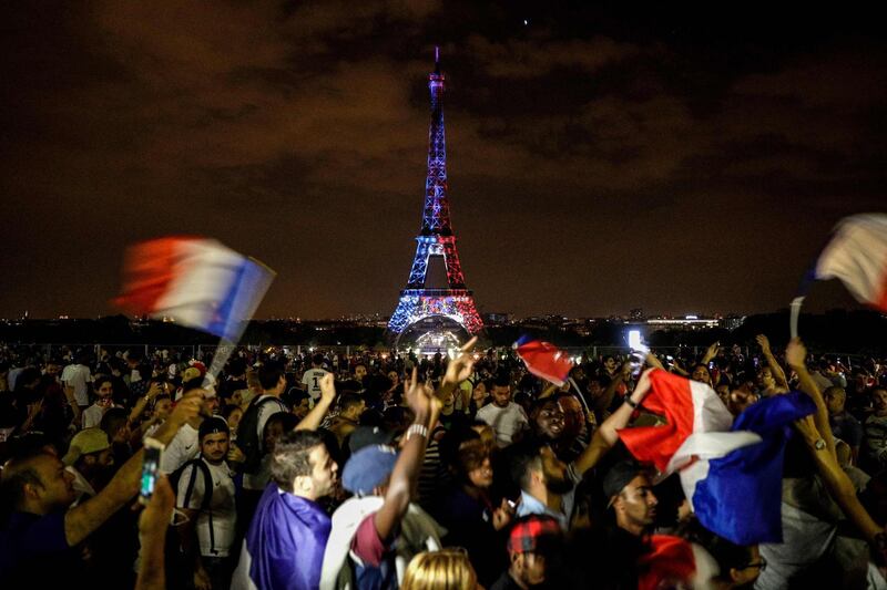 TOPSHOT - This picture taken from Trocadero on July 15, 2018 shows the Eiffel Tower illuminated in French national colors during celebrations after the Russia 2018 World Cup final football match between France and Croatia, on the Champs-Elysees avenue in Paris.  / AFP / Geoffroy VAN DER HASSELT
