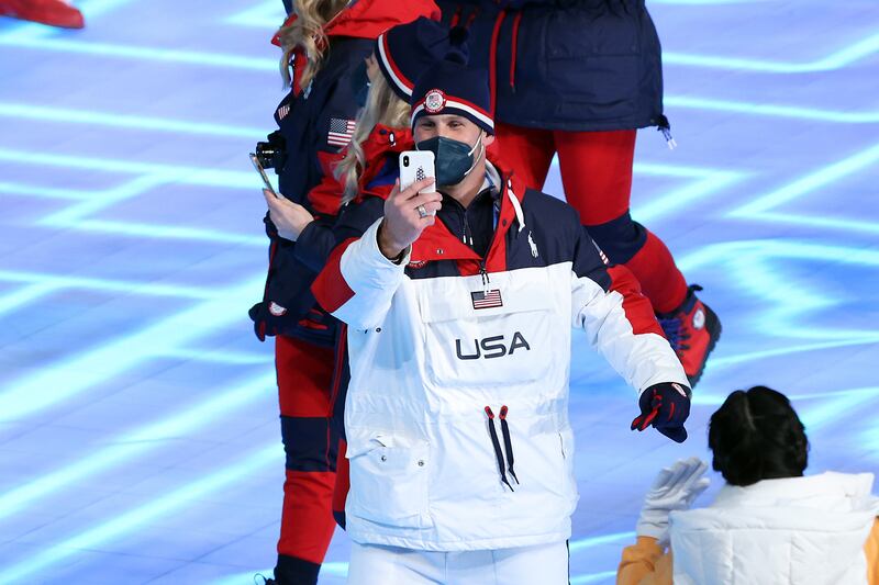 A Team USA athlete takes a photograph as he walks in the opening ceremony. Getty Images