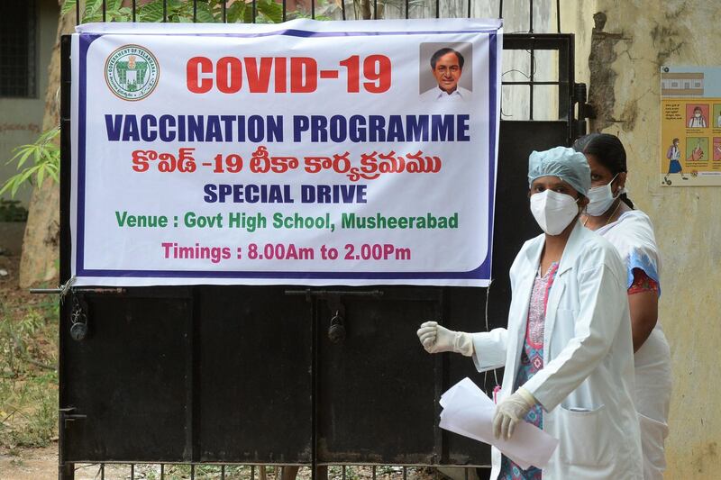 A doctor passes a banner  in Hyderabad announcing a special vaccination programme against Covid-19. AFP