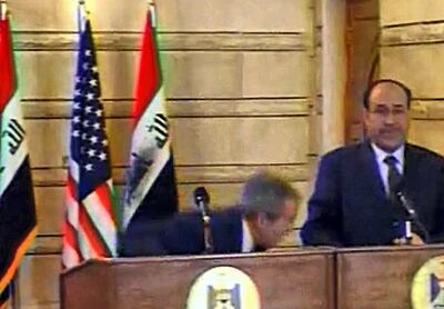 An image grab taken from footage broadcast by the Al-Arabiya news channel shows US President George W. Bush (L) reacting as an Iraqi journalist hurls one of his shoes at him during a joint press conference with Iraqi Prime Minister Nuri al-Maliki (R) in Baghdad on December 14, 2008. Muntazer al-Zaidi from Al-Baghdadia channel hurled his shoes and an insult at Bush, without hitting him, as the US president was shaking hands with the Iraqi premier at his Baghdad office today. Zaidi jumped up, shouting: "It is the farewell kiss, you dog," and threw his shoes one after the other towards Bush. Maliki made a protective gesture towards the US president, who ducked and was not hit. AFP PHOTO/DSK == RESTRICTED TO EDITORIAL USE == / AFP PHOTO / AL-ARABIYA