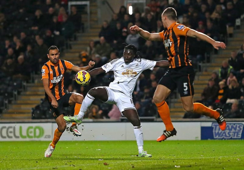 Bafi Gomis of Swansea is challenged by Ahmed Elmohamady of Hull City during their match at KC Stadium on December 20, 2014 in Hull, England. Paul Thomas / Getty Images