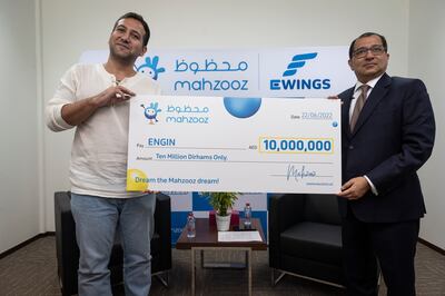 Turkish civil engineer Engin (left) is presented with his Dh10 million cheque by Farid Samji, chief executive of Ewings, the operator of Mahzooz. Photo: Antonie Robertson / The National