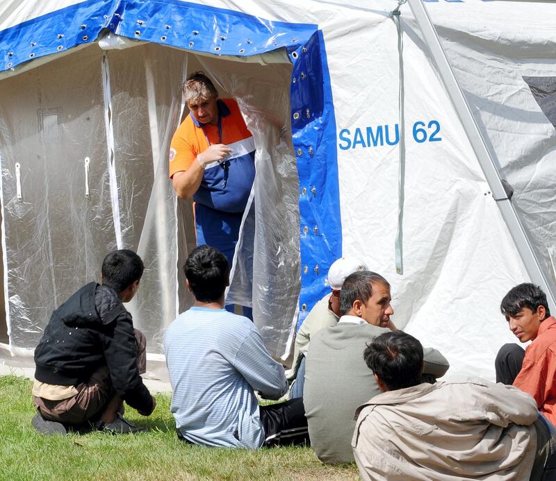 Illegal immigrants wait to take a shower and to be examined by doctors on August 11, 2009 in Calais, a key exit point to Britain in northern France, after scabies plague is extending among the immigrant population.    AFP PHOTO DENIS CHARLET / AFP PHOTO / DENIS CHARLET