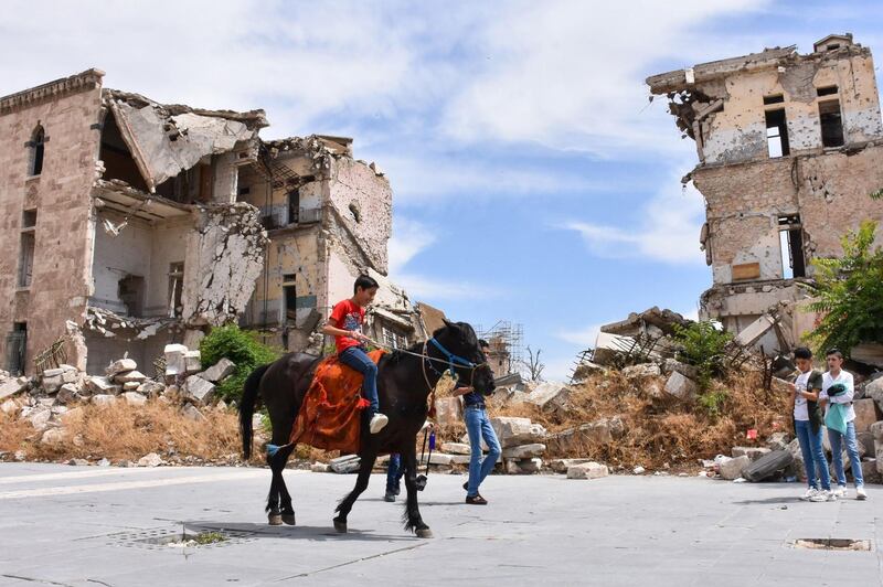 A boy rides a horse near the Citadel of Aleppo on the third day of Eid Al Fitr holiday as coronavirus restrictions are eased amid the Covid-19 pandemic, in northern Syria. AFP
