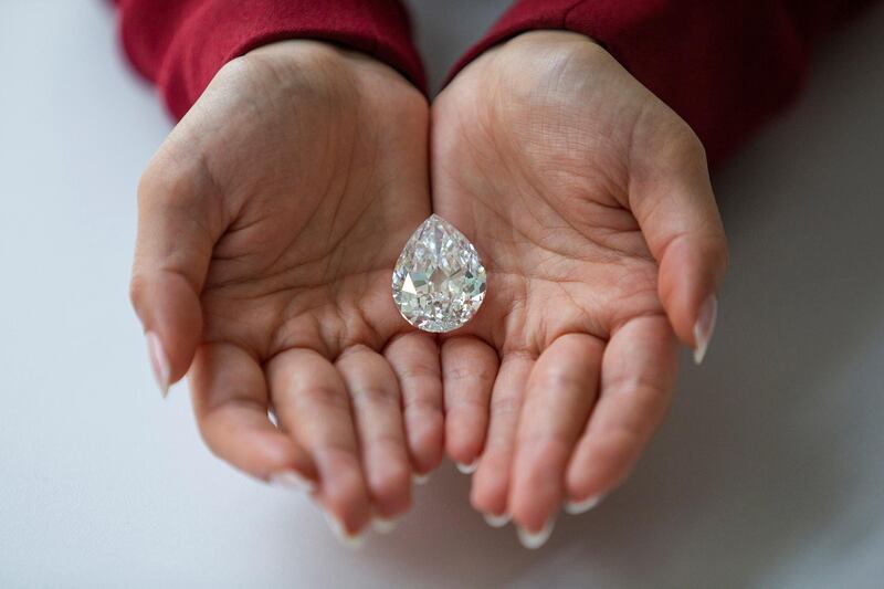 An employee of Sotheby's poses with a rare flawless 100+ carat diamond at Sotheby's in New York. Courtesy Sotheby's