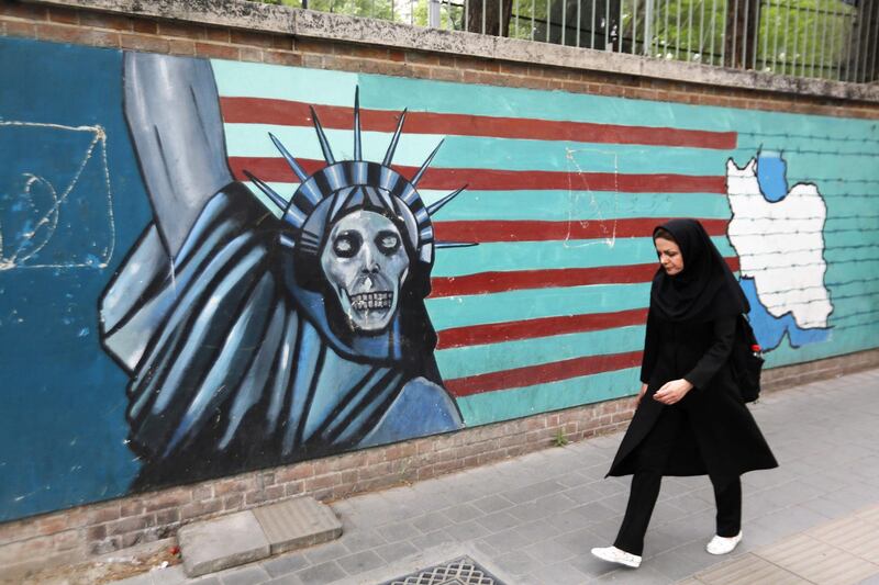 An Iranian woman walks past a mural on the wall of the former US embassy in the Iranian capital Tehran on May 8, 2018.
US President Donald Trump is due to make his decision on whether to rip up the 2015 nuclear deal and reimpose sanctions on Iran.  / AFP PHOTO / ATTA KENARE