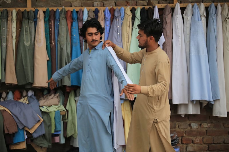 Trying on second-hand clothes before Eid Al Fitr in Peshawar, Pakistan. EPA