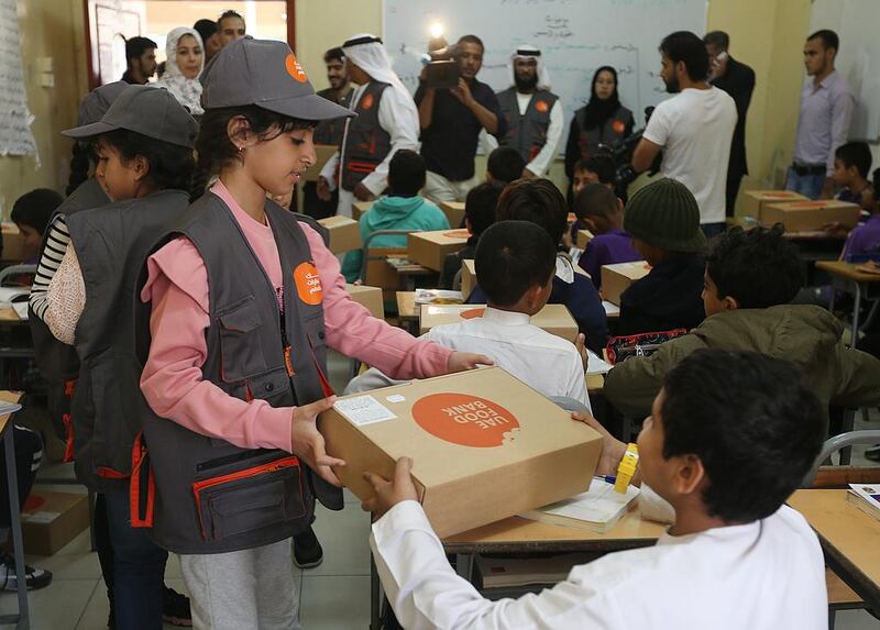 Volunteers distribute food boxes at Manar Al Eman Charity School as part of UAE Food Bank Initiative in Ajman. Satish Kumar / The National