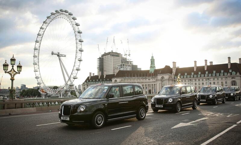 A convoy of electric London black cabs drive across Westminster Bridge, with the London Eye behind, to mark the milestone of having 350 London electric black taxis on London roads, Monday July 9, 2018.  The London Electric Vehicle Company say 350 taxis are expected to annually cover around 10.7 million miles (17.2 million KM), saving their owners about 1.8 million pounds (12.25 million euro) in fuel costs and reduce CO2 emissions from the taxi sector by some 2,450 tonnes. (Matt Alexander/PA via AP)