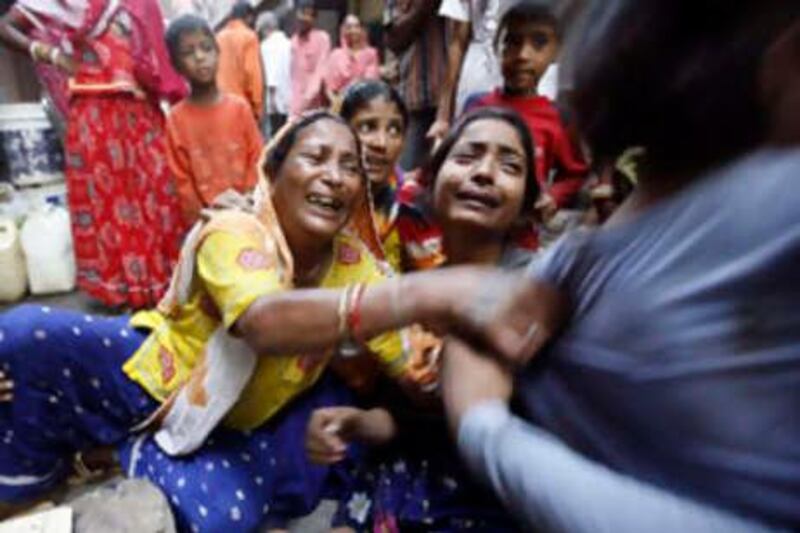 Relatives of bomb blast victims wail in New Delhi, India, Sunday, Sept. 14, 2008. India police say they have detained several people in raids carried out across New Delhi a day after a series of blasts ripped through the Indian capital, killing at least 20 people. (AP Photo/Mustafa Quraishi) *** Local Caption ***  MQX115_India_Blasts.jpg