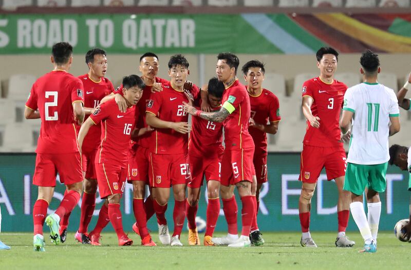 China's players celebrate with Zhu Chenjie after he scored the equaliser against Saudi Arabia in Sharjah. Pawan Singh / The National  