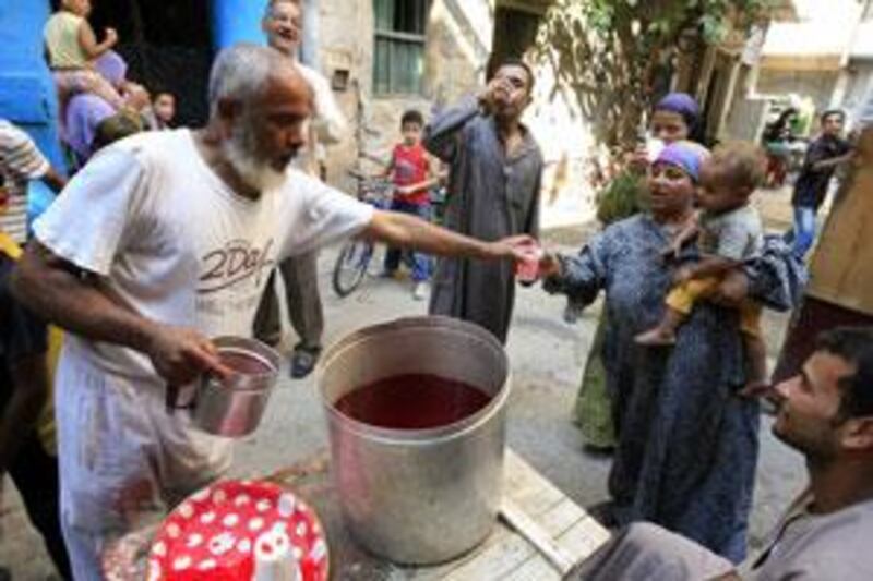 An Egyptian man distributes shardap to poor people at a banned moulid near the downtown Sayyida Zeinab mosque.