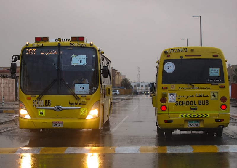 School buses transport children in the rain.