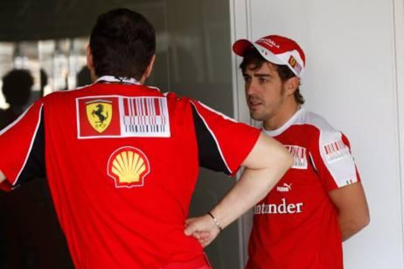Ferrari's Formula One driver Fernando Alonso, of Spain, right, talks to a team member at the Interlagos race track in Sao Paulo, Brazil, Thursday, Nov. 4, 2010. (AP Photo/Luca Bruno) *** Local Caption ***  XRM103_Brazil_F1_GP_Auto_Racing.jpg