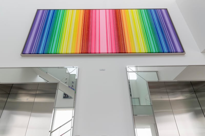 A huge rainbow-hued artwork by artist Stefania Nazzal hangs in the double-height space above the private lifts in Stanbury’s Dubai penthouse. Antonie Robertson / The National