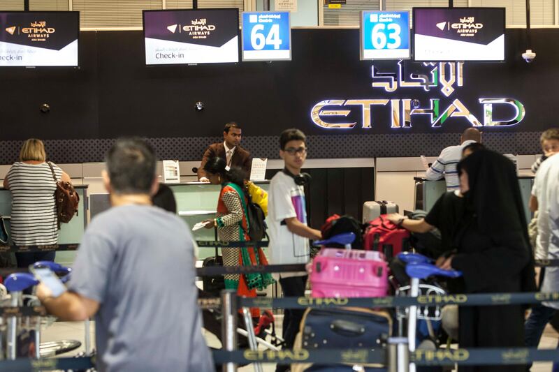 Passengers check-in for flights at the Abu Dhabi International Airport. Antonie Robertson / The National