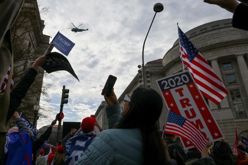 Marine One, carrying U.S. President Donald Trump, passes over people attending a rally to protest the results of the election in front of Supreme Court building, in Washington, U.S., December 12, 2020. REUTERS/Jonathan Ernst