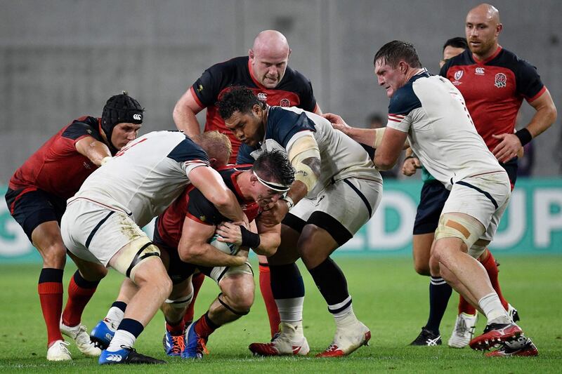 England flanker Tom Curry, centre, is tackled by US lock Ben Landry, second right, during the Pool C match. AFP